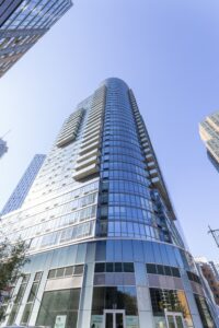 The Eagle, 86 Fleet Place at Myrtle Avenue in Downtown Brooklyn, is a curved-corner glass apartment tower with balconies.